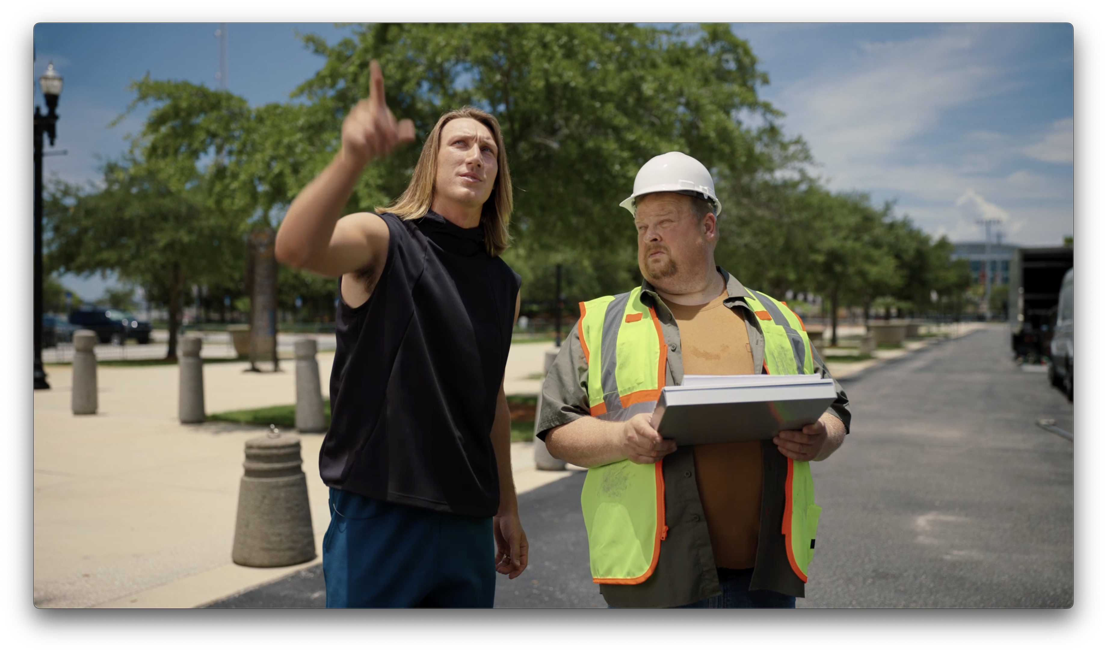 Trevor Lawrence standing next to a construction worker and pointing